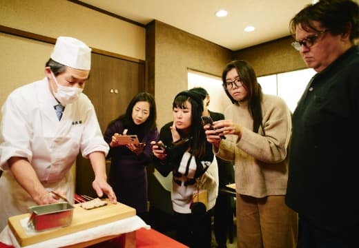 料理人を見る観光客